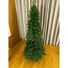 A tall, artificial Christmas tree stands on a wooden floor in front of beige curtains. Podgląd zdjęcia produktu