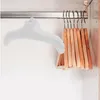 An inflatable white clothes hanger is hanging on a closet rod next to a set of wooden hangers. Produktbild-Vorschau
