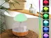 A mushroom-shaped humidifier with RGB lighting is placed on a wooden surface next to a bathtub. Náhled obrázku produktu