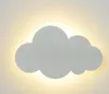 A cloud-shaped wall lamp emitting warm white light against a wall. Produktbild-Vorschau