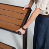 A person's hands are shown adjusting a wooden bench. Podgląd zdjęcia produktu
