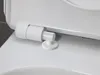 A close-up view of the hinge mechanism of a white toilet seat. Produktbild-Vorschau