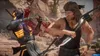 A violent scene from a video game, showing a character impaling another with a knife. Produktbild-Vorschau