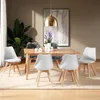 A dining room setting with a wooden table and four white chairs. Produktbild-Vorschau