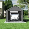 A grey carport tent is set up on a grassy lawn, with a white trailer inside. A house is visible to the left, and trees are in the background. Produktbild-Vorschau