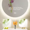 A round LED mirror with a frosted edge, showing a plant and text describing the light quality, with two smaller inset images comparing the mirror's reflection. Anteprima dell’immagine prodotto