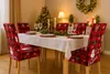 A dining table set for Christmas with chair covers, a Christmas tree, and decorations. Náhled obrázku produktu