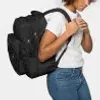 A person wearing a black backpack. Produktbild-Vorschau