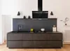 A modern kitchen island with a black range hood and dark gray cabinets. Produktbild-Vorschau