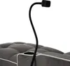 A close-up view of a gray tufted sofa with a black gooseneck lamp and a cup holder. Produktbild-Vorschau