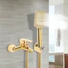 A gold-colored shower set, including a faucet and a handheld showerhead, mounted on a textured wall. Podgląd zdjęcia produktu