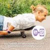 A young girl lying on a skateboard, wearing a pink smartwatch. Produktbild-Vorschau