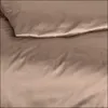 A close-up view of taupe-colored bedding, showing the texture and folds of the fabric. Produktbild-Vorschau