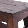 A close-up view of the corner of a dark brown wooden stool. Produktbild-Vorschau