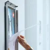 A person is inserting a document into a poster frame mounted on a wall. Voir les images du produit