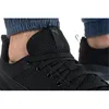 A close-up view of a black Puma sports shoe on a person's foot. Produktbild-Vorschau