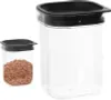 Two transparent food storage containers with black lids are shown against a white background. One container is larger and empty, while the smaller one on the left is filled with a granular food item. Náhľad obrázku produktu