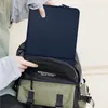 A person is putting a navy blue laptop sleeve into a backpack. Anteprima dell’immagine prodotto