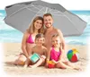 A family of four is sitting on a beach under a gray beach umbrella, with the ocean in the background. Náhled obrázku produktu