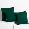 Four dark green pillows are arranged on a white surface against a white background. Produktbild-Vorschau