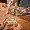 Two people assembling a wooden model of Notre-Dame Cathedral on a wooden table. Náhled obrázku produktu