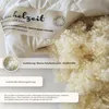 A close-up view of a fluffy pillow filling and its label. Produktbild-Vorschau