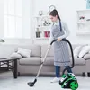 A woman is vacuuming a living room floor with a bagless vacuum cleaner. Produktbild-Vorschau