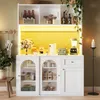 A white storage cabinet with glass doors, displaying various kitchen items and decor, illuminated by yellow LED lighting. Náhľad obrázku produktu