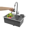 A hand is shown rinsing vegetables in a kitchen sink with a pull-out faucet. Podgląd zdjęcia produktu
