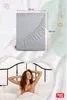 A fitted sheet is shown with dimensions, and a woman is relaxing in bed. Produktbild-Vorschau