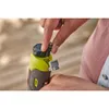 A person is holding and interacting with a small, green and gray power tool, possibly inserting or removing a bit. Produktbild-Vorschau