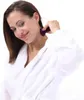 A woman in a white bathrobe is using a purple beauty tool on her neck. Produktbild-Vorschau