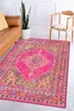 A colorful rug is placed on the floor in a living room setting, next to a brown leather sofa and a wooden chair. Podgląd zdjęcia produktu