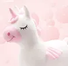 A plush white unicorn toy with pink accents, set against a soft pink background with blurred pink bubbles. Náhľad obrázku produktu