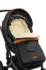 A close-up view of a black stroller footmuff with a cream-colored fuzzy lining and brown leather accents. Náhľad obrázku produktu