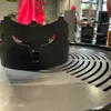 A close-up view of a black metal grill accessory with a slotted surface in the foreground. Produktbild-Vorschau