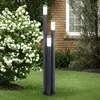 A garden scene with a three-pillar lamp and a flowering bush. Produktbild-Vorschau