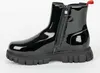 A black patent leather boot with a zipper and a red pull tab, shown from the side against a white background. Produktbild-Vorschau