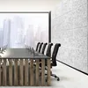 A modern conference room with a large window overlooking a city skyline, a long conference table with laptops, and acoustic wall panels. Produktbild-Vorschau