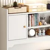 A close-up view of a white shelf unit with various items on it, including books, decorative objects, and storage boxes. Podgląd zdjęcia produktu