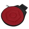 A round, red seat cushion with a black border and a black strap on a white background. Náhled obrázku produktu