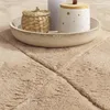 A close-up view of a textured rug with a decorative bowl containing a small woven basket and a lidded jar. Anteprima dell’immagine prodotto