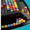 A close-up of a board game with colorful marbles. Produktbild-Vorschau