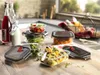A collection of glass food storage containers filled with various foods, arranged on a wooden countertop. Produktbild-Vorschau