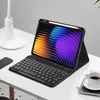A tablet with a keyboard case and stylus on a desk. Produktbild-Vorschau
