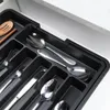 A black cutlery organizer filled with silverware in a drawer. Produktbild-Vorschau
