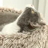 A close-up shot of a cat lying in a fluffy bed. Podgląd zdjęcia produktu