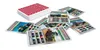 A stack of playing cards with tractor images and statistics, scattered around a deck of cards. Produktbild-Vorschau