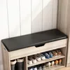 A shoe cabinet with a bench seat, showing various shoes stored on shelves. Podgląd zdjęcia produktu