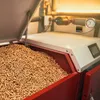 A close-up view of a pellet boiler filled with wood pellets. Produktbild-Vorschau